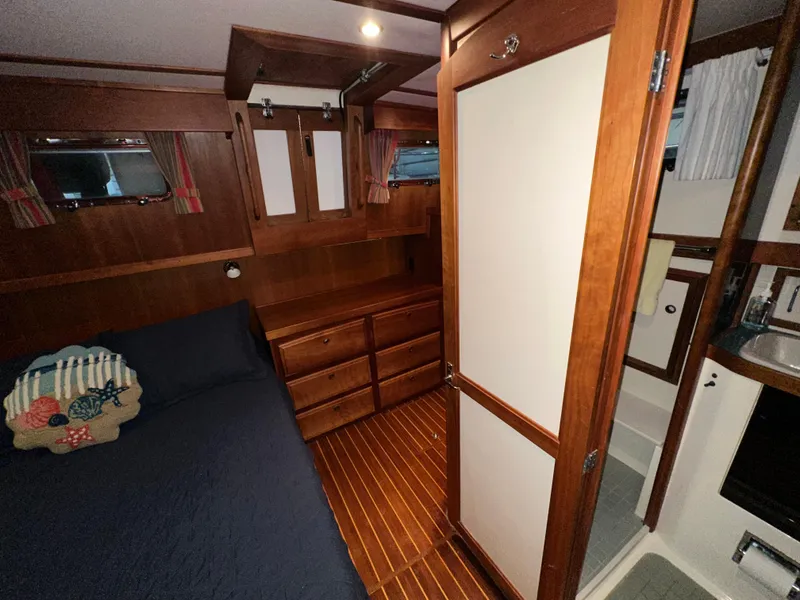 Slide: The Image of 2001 Sabreline 43 yacht interior with wooden cabinetry, bed, and bathroom. - 40