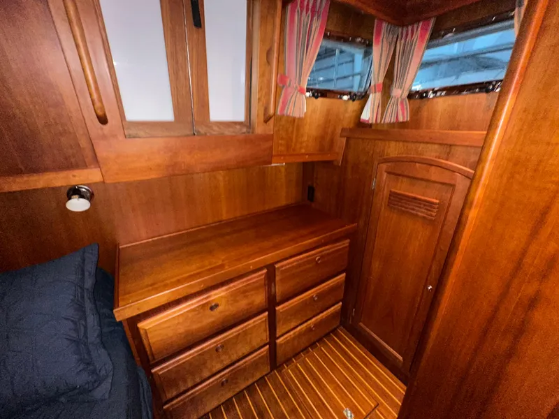 Slide: The Image of Interior of 2001 Sabreline 43 yacht with wooden cabinetry and striped curtains. - 43