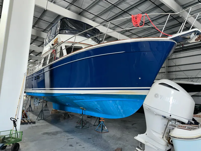 Slide: The Image of 2001 Sabreline 43 boat in storage, blue hull, indoor facility, Yamaha engine visible. - 5