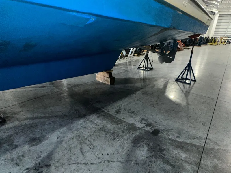Slide: The Image of 2001 Sabre Sabreline 43 yacht on stands in a warehouse, blue hull visible. - 8