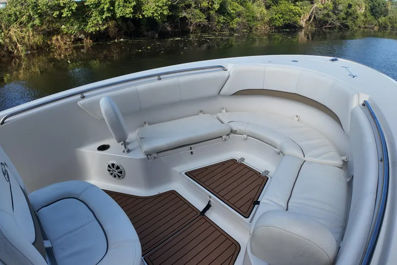 Slide: The Image of 2015 Sportsman Heritage 231 Center Console boat interior with cushioned seating and wood flooring. - 16
