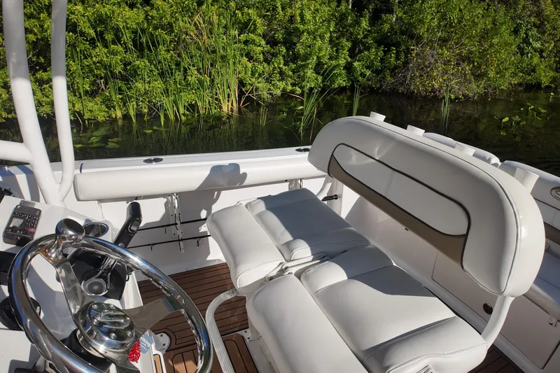 Slide: The Image of 2015 Sportsman Heritage 231 Center Console boat interior with white seating and steering wheel. - 18