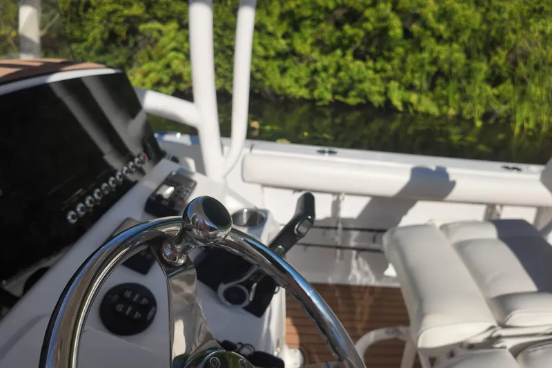 Slide: The Image of 2015 Sportsman Heritage 231 Center Console boat interior with steering wheel and controls. - 19