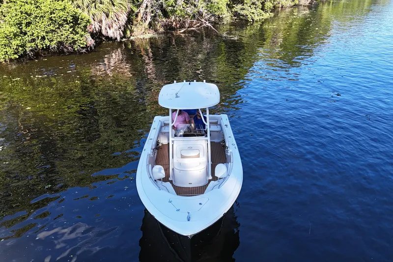Slide: The Image of 2015 Sportsman Heritage 231 Center Console boat on calm water near lush greenery. - 5