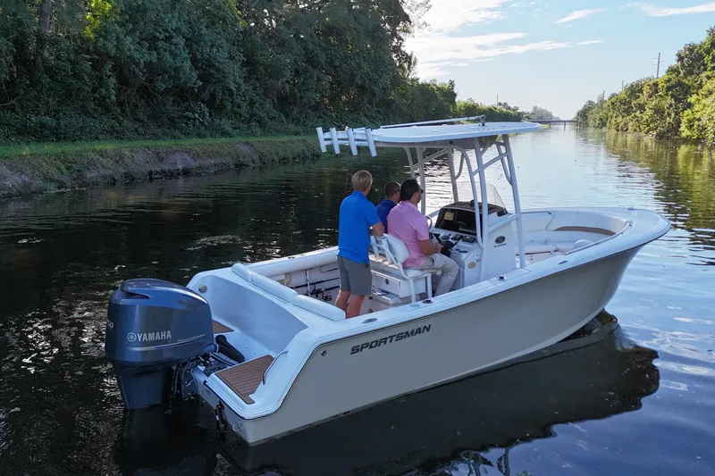 Slide: The Image of 2015 Sportsman Heritage 231 Center Console boat on a calm river with three people onboard. - 9