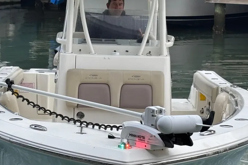 Slide: The Image of 2017 Cobia 296 Center Console boat with Minn Kota Terrova motor in a marina. - 13