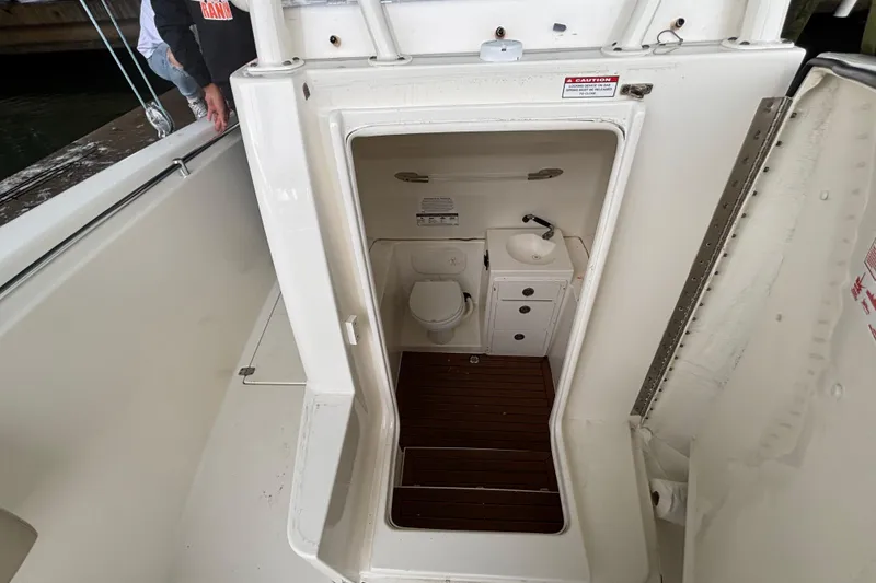 Slide: The Image of 2017 Cobia 296 Center Console boat interior with compact bathroom and sink. - 16