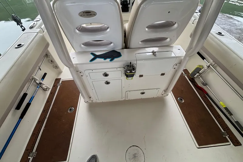 Slide: The Image of 2017 Cobia 296 Center Console boat interior with fishing gear and storage compartments. - 17