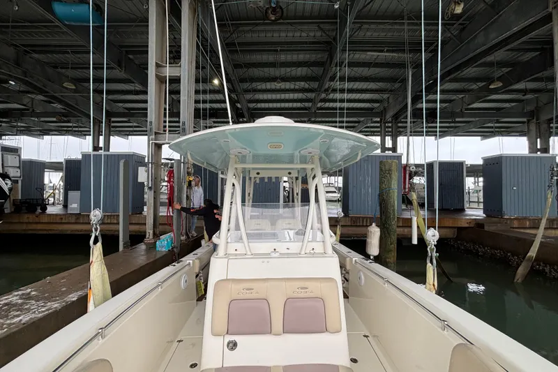 Slide: The Image of 2017 Cobia 296 Center Console boat docked in a marina under a covered structure. - 25