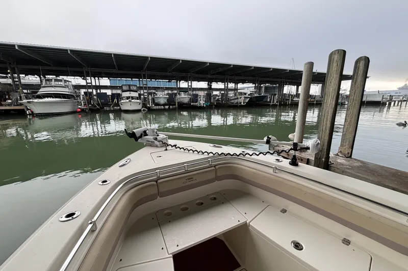 Slide: The Image of 2017 Cobia 296 Center Console boat docked at marina with covered slips. - 26