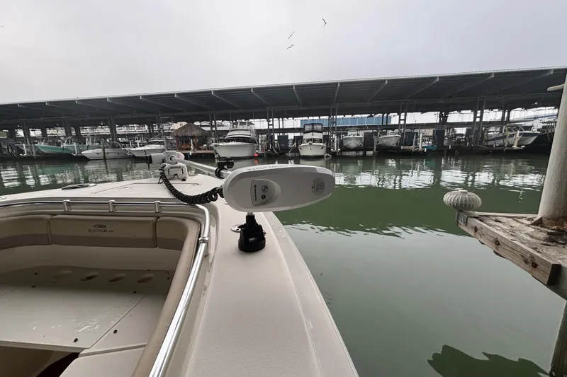 Slide: The Image of 2017 Cobia 296 Center Console boat docked in a marina with covered slips. - 27