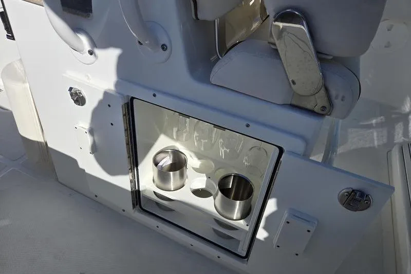 Slide: The Image of 2026 Sea Hunt Ultra 275 SE boat interior with cup holders and storage compartment. - 21
