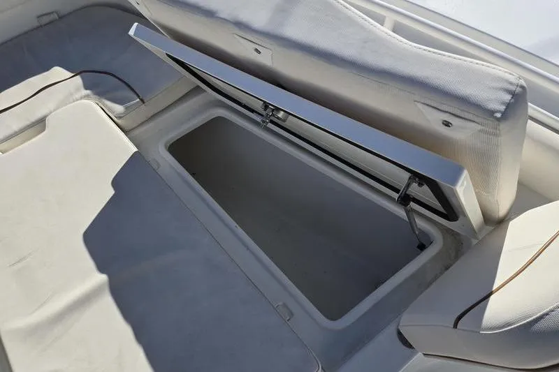 Slide: The Image of 2026 Sea Hunt Ultra 275 SE boat storage compartment with open cushioned seat. - 4