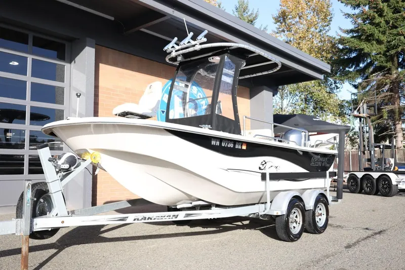 Slide: The Image of 2013 Carolina Skiff 178 DLV boat on trailer outside a garage. - 14