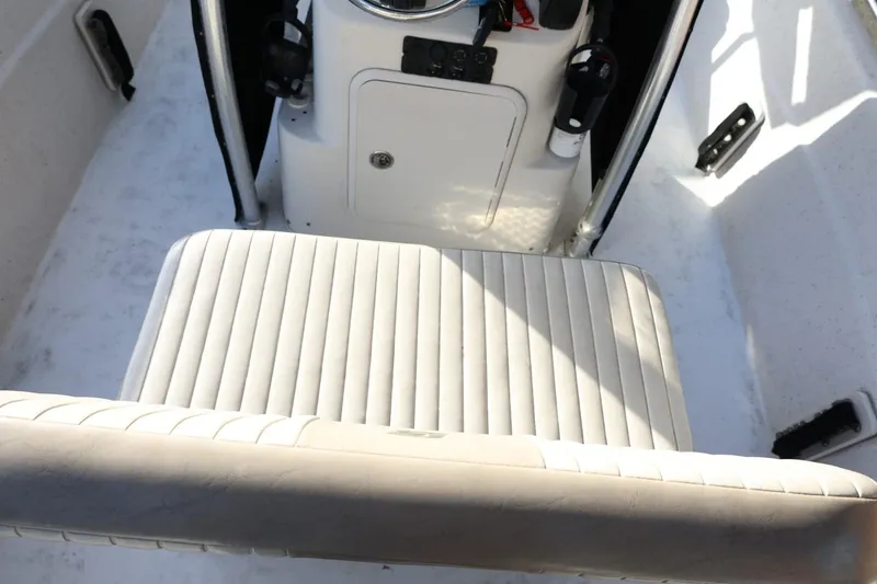Slide: The Image of 2013 Carolina Skiff 178 DLV boat interior with white cushioned seating and console. - 18