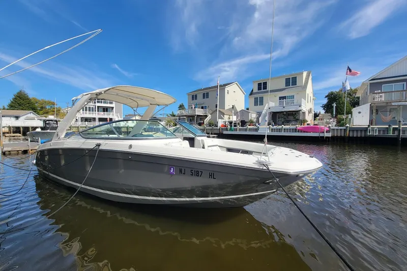 The Image of 2018 Regal 26 OBX boat docked in a residential canal under a clear blue sky. - 0