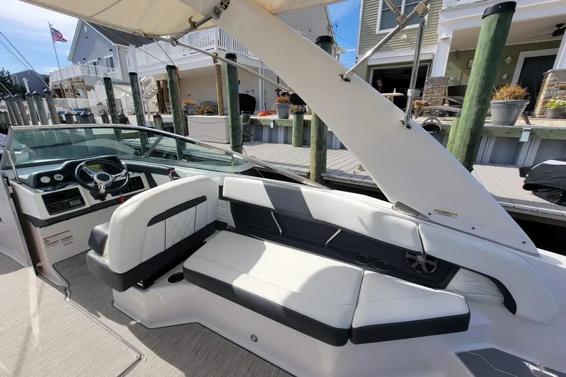 Slide: The Image of 2018 Regal 26 OBX boat interior with white seating, dockside view. - 8
