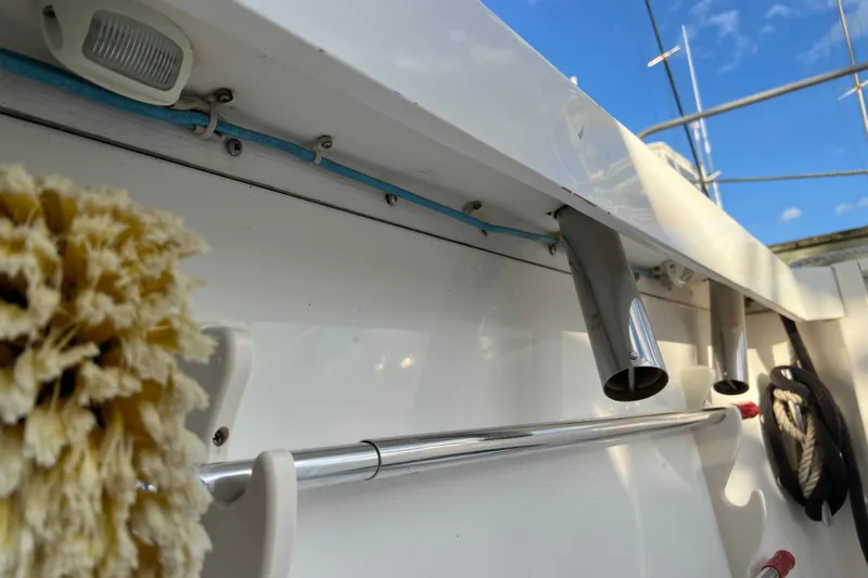 Slide: The Image of 2004 Henriques 35 Sportfisherman boat deck with cleaning brush and rod holders. - 10