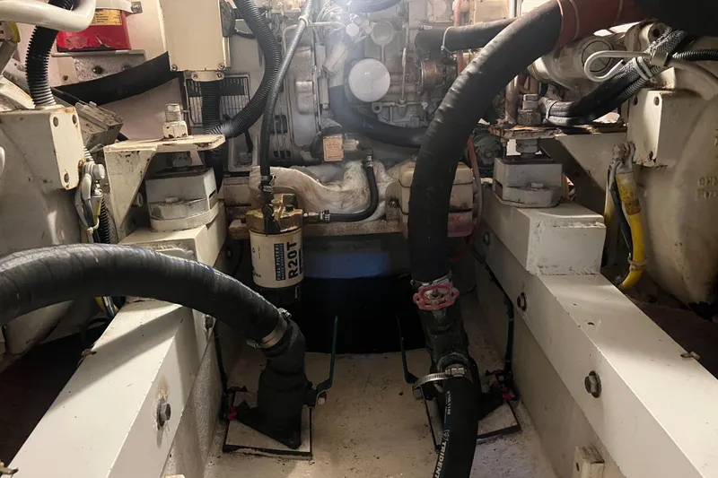 Slide: The Image of Engine room of a 2004 Henriques 35 Sportfisherman, showcasing mechanical components and hoses. - 100