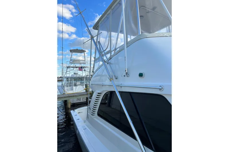 Slide: The Image of 2004 Henriques 35 Sportfisherman docked, showcasing sleek design and fishing equipment. - 128