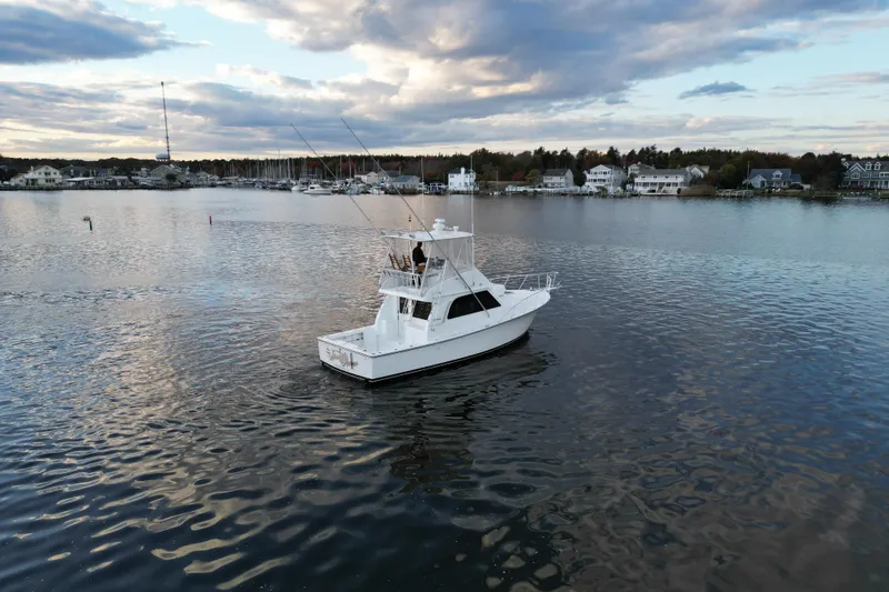 Slide: The Image of 2004 Henriques 35 Sportfisherman boat on calm water, scenic coastal backdrop. - 129
