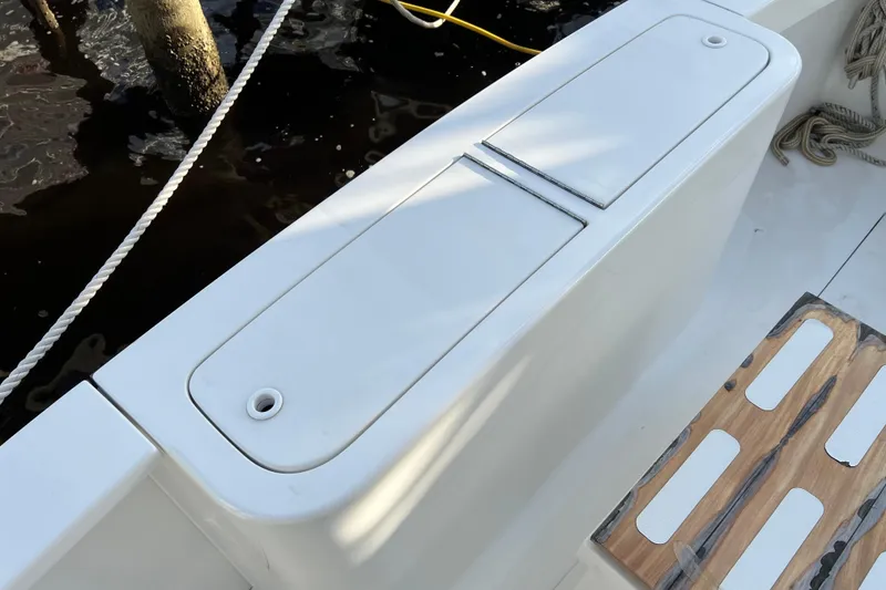 Slide: The Image of 2004 Henriques 35 Sportfisherman boat deck with storage compartment and wooden step. - 18