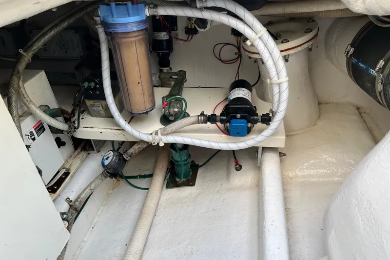 Slide: The Image of Engine room of 2004 Henriques 35 Sportfisherman, showcasing mechanical components and piping. - 26