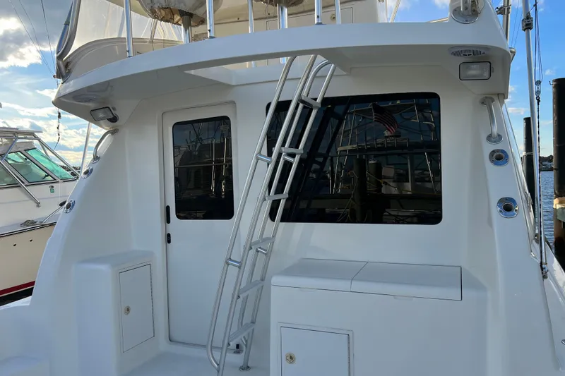 Slide: The Image of 2004 Henriques 35 Sportfisherman boat with ladder and window, docked at marina. - 28