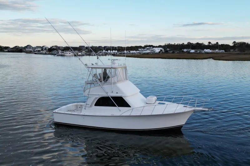 Slide: The Image of 2004 Henriques 35 Sportfisherman boat on calm water, coastal background. - 3