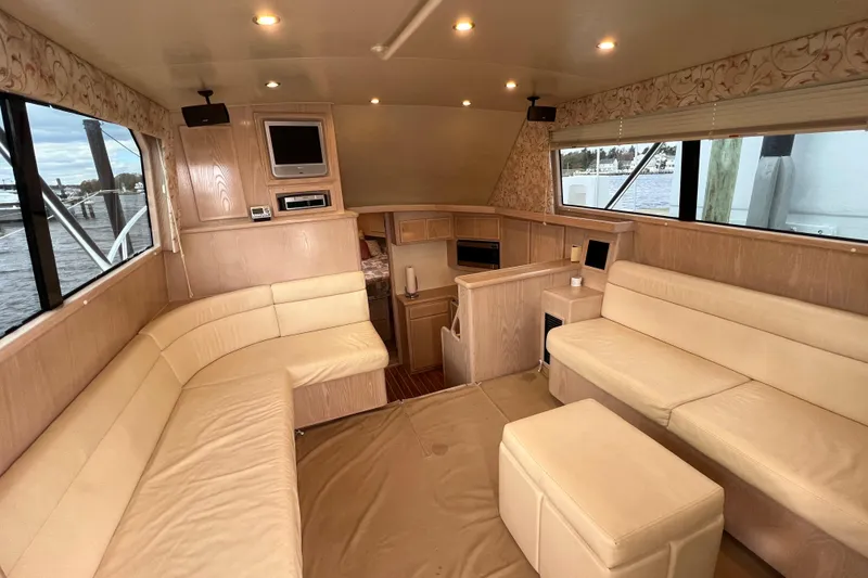 Slide: The Image of Luxurious interior of a 2004 Henriques 35 Sportfisherman yacht with beige seating and wood accents. - 37