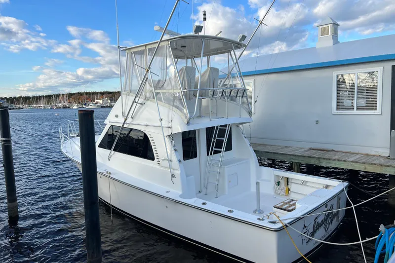Slide: The Image of 2004 Henriques 35 Sportfisherman docked by a marina, under a partly cloudy sky. - 4