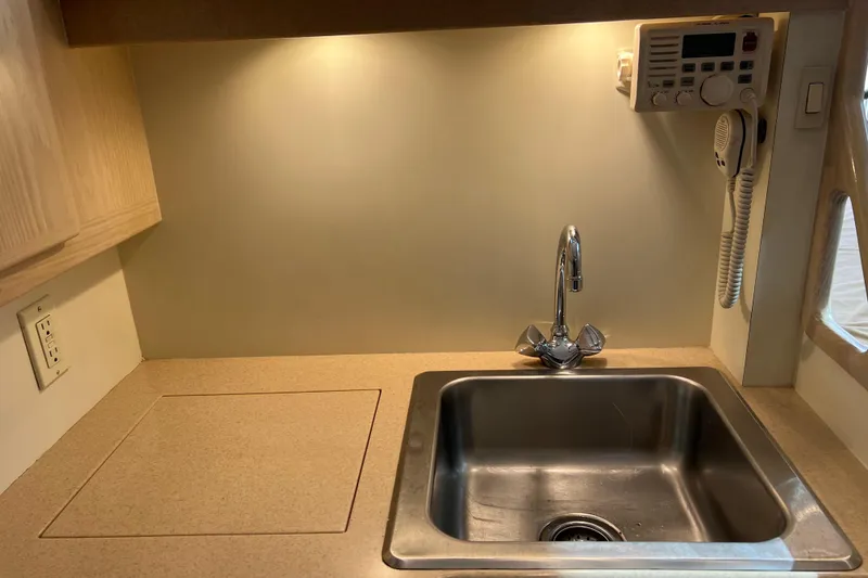 Slide: The Image of 2004 Henriques 35 Sportfisherman galley with sink, countertop, and radio. - 53