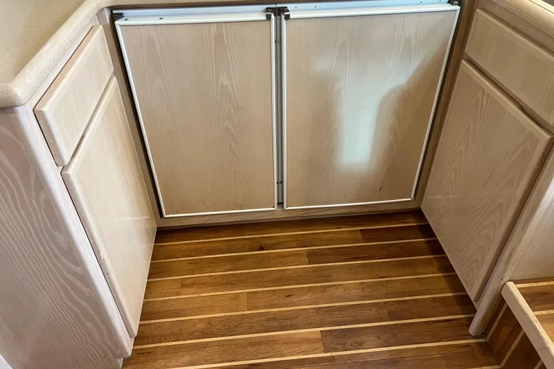 Slide: The Image of Wooden cabinetry and flooring inside a 2004 Henriques 35 Sportfisherman boat. - 58