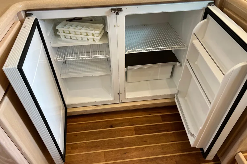Slide: The Image of Open refrigerator on 2004 Henriques 35 Sportfisherman boat, showing shelves and ice tray. - 59