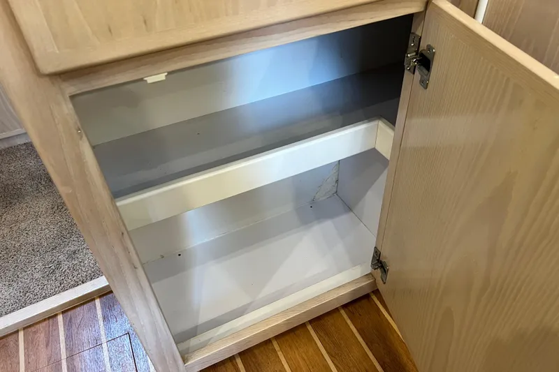 Slide: The Image of Open wooden cabinet on 2004 Henriques 35 Sportfisherman boat, showing empty interior shelves. - 61