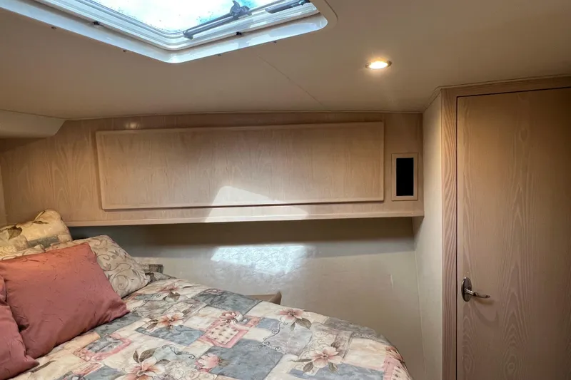 Slide: The Image of Cozy cabin interior of 2004 Henriques 35 Sportfisherman with floral bedding and wood paneling. - 76