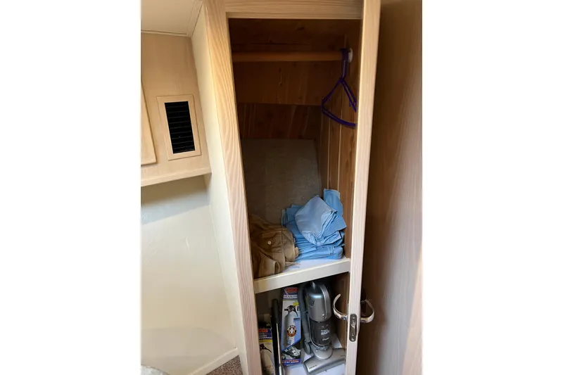 Slide: The Image of 2004 Henriques 35 Sportfisherman interior closet with clothes and cleaning supplies. - 77