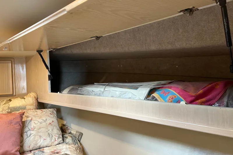 Slide: The Image of Storage compartment in 2004 Henriques 35 Sportfisherman, with colorful blankets and pillows. - 78