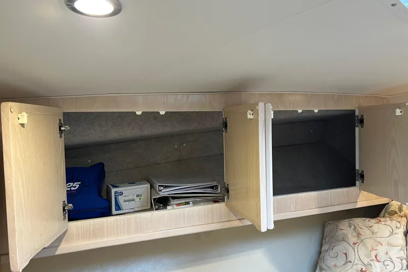 Slide: The Image of Open wooden cabinets inside a 2004 Henriques 35 Sportfisherman boat, showing storage space. - 80