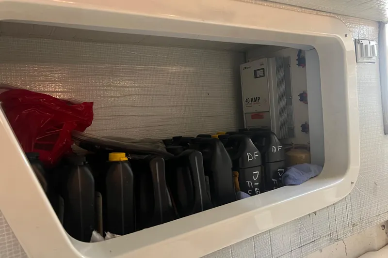 Slide: The Image of Storage compartment on a 2004 Henriques 35 Sportfisherman with oil containers and electrical panel. - 86