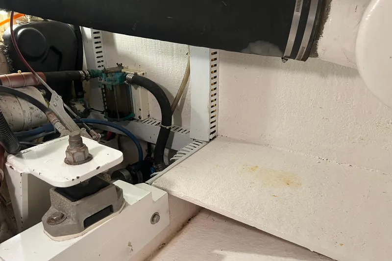 Slide: The Image of Engine compartment of a 2004 Henriques 35 Sportfisherman, showcasing mechanical components and hoses. - 90