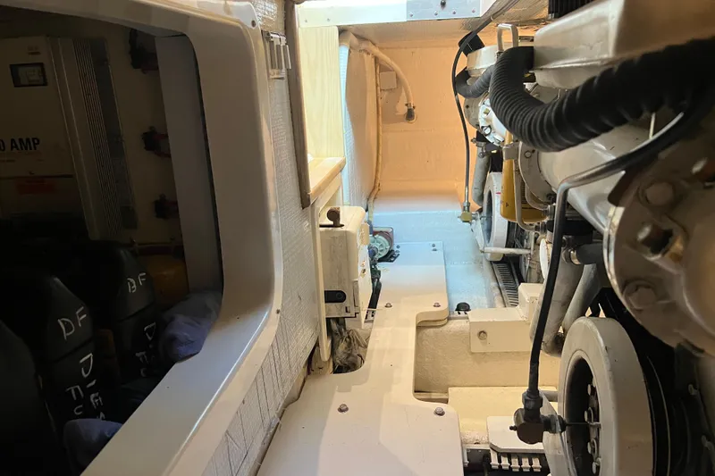 Slide: The Image of Engine room of a 2004 Henriques 35 Sportfisherman, showcasing mechanical components and wiring. - 93