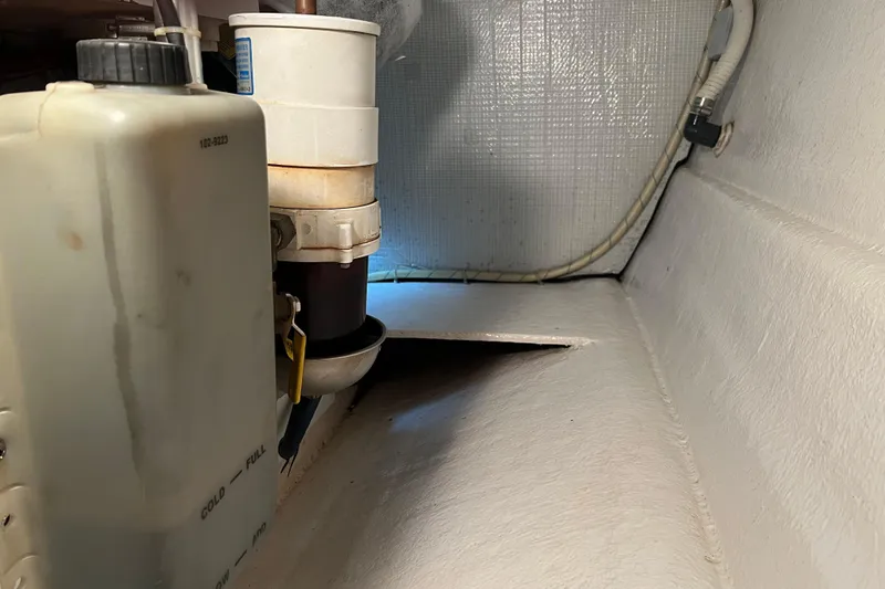 Slide: The Image of Engine compartment of a 2004 Henriques 35 Sportfisherman boat, showing fuel filter and hoses. - 98