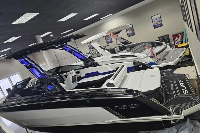 Slide: The Image of 2026 Cobalt R8 Surf boat in showroom, sleek design with illuminated features. - 5