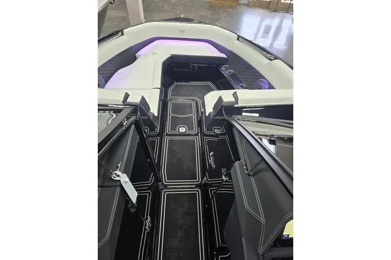 Slide: The Image of 2026 Cobalt R8 Surf boat interior with sleek black flooring and modern seating. - 8