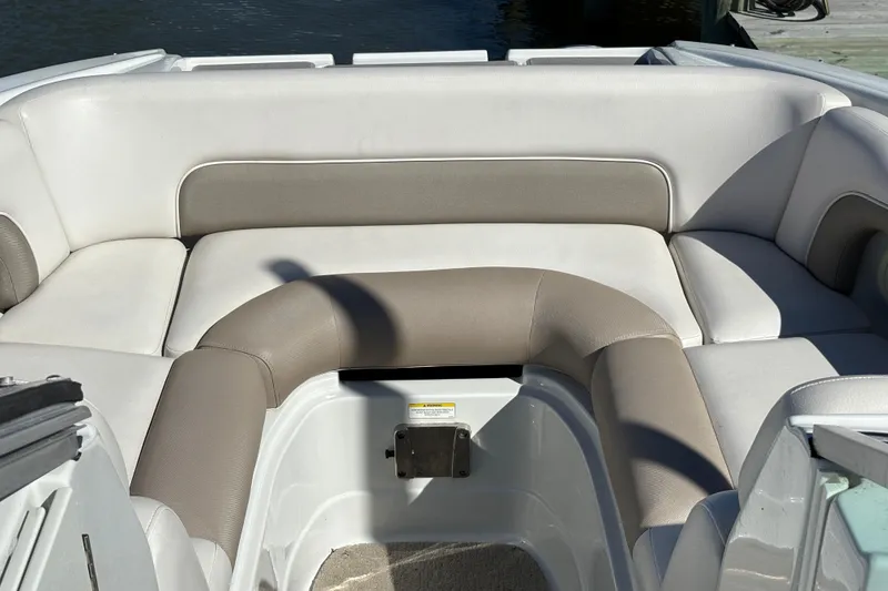 Slide: The Image of 2014 Crownline Eclipse E2 XS boat interior with cushioned seating in neutral tones. - 11