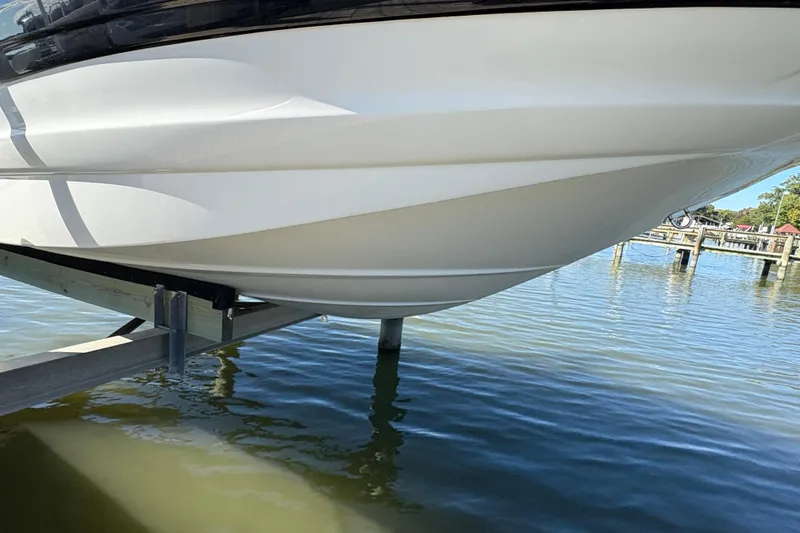 Slide: The Image of 2014 Crownline Eclipse E2 XS boat hull on lift over water. - 14