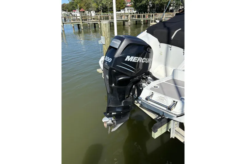 Slide: The Image of 2014 Crownline Eclipse E2 XS with Mercury outboard motor docked by the water. - 4