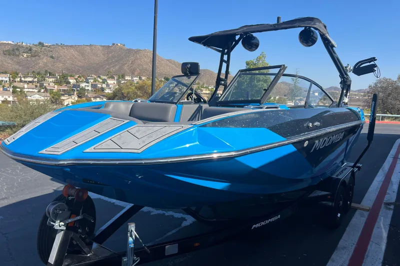 Slide: The Image of 2022 Moomba Kaiyen boat interior with blue and gray seating, modern dashboard. - 10