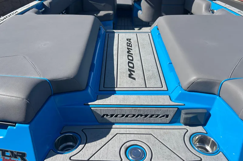 Slide: The Image of 2022 Moomba Kaiyen boat interior with gray seating and blue accents. - 12